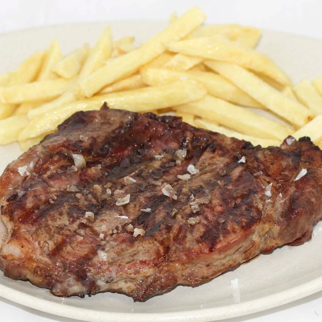 Beef sirloin steak over charcoal with fries — The Beefeater Fuengirola