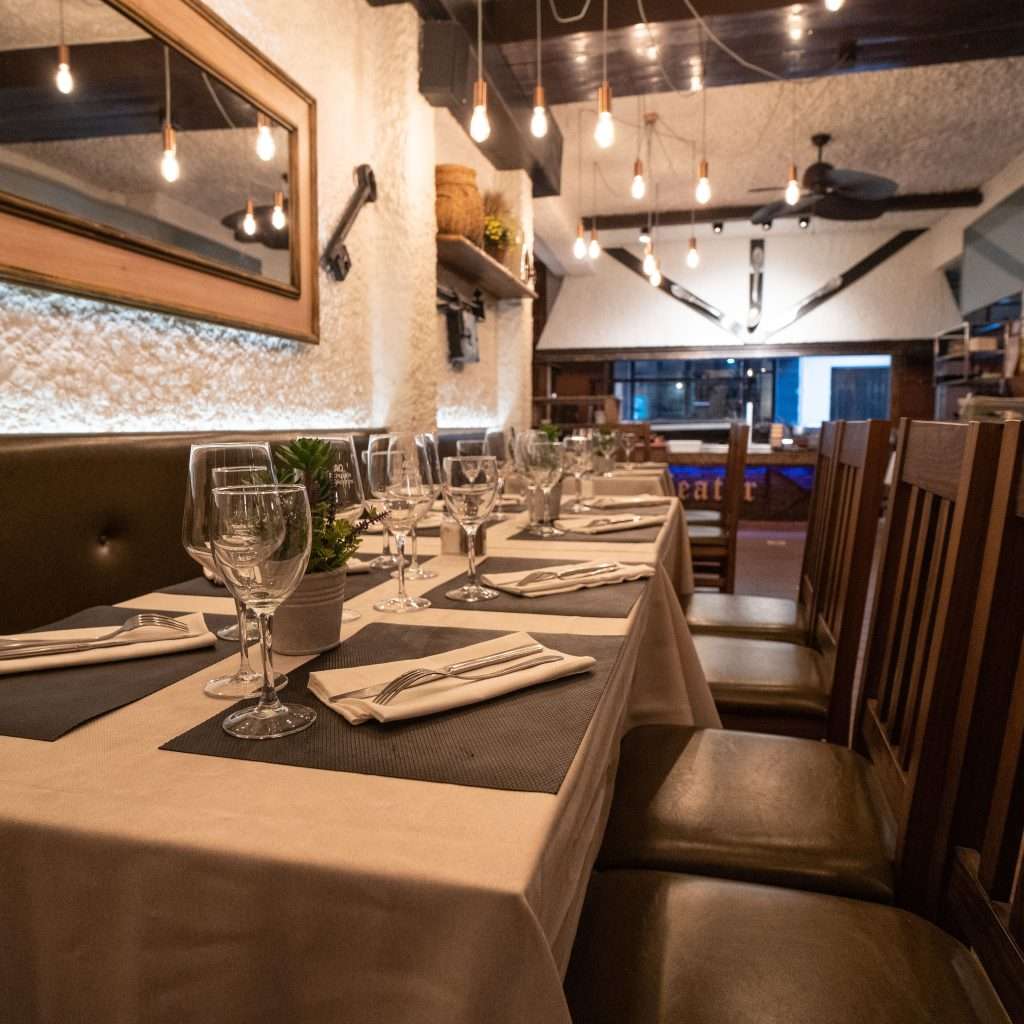 Sala interior con mesas preparadas y banquetas en el asador The Beefeater Fuengirola